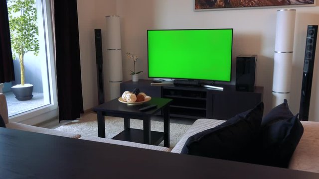 A TV with a green screen in a living room