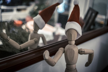 Wooden toy dummy with Christmas decoration hat on a home lounge scene