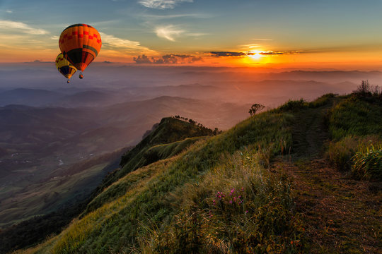 Hot air balloons floating up to the sky over mountain landscape