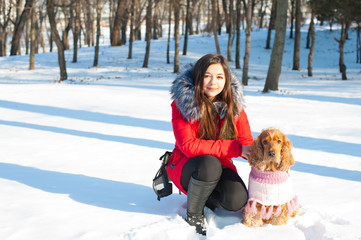 Obraz premium Young woman with cocker spaniel dog in winter park 