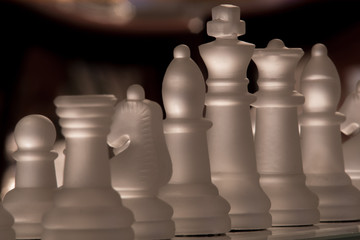 Closeup of a row of chess pieces in frosted glass