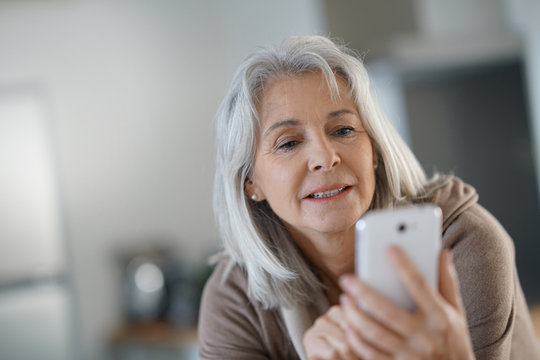 Senior woman relaxing and using smartphone