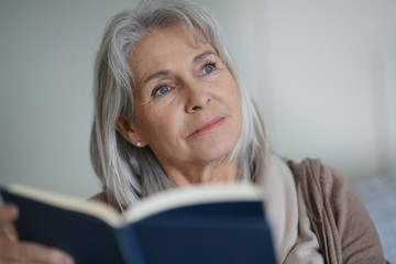 Senior woman reading book at home