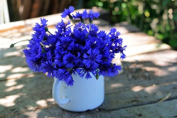bouquet of wild flowers blue cornflowers on an old wooden table