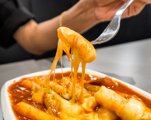 Women holding fork with tteokbokki cheese