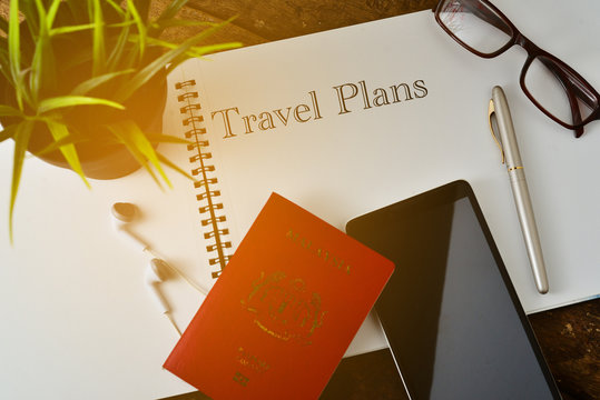 "Travel Concept " info text Travel Plans on note book with smart phone,passport,earphone,pen and glasses.Top View.
