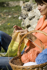 femme qui se détend en tricotant dans l'herbe