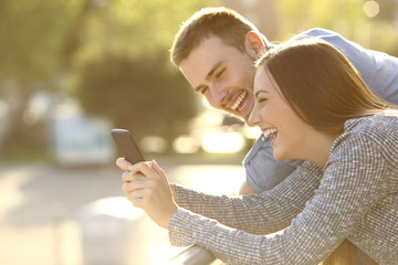 Couple laughing with media content in a phone
