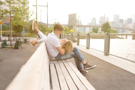 Young Goofy Couple Being Funny sitting on a Bench in Brooklyn . New York City