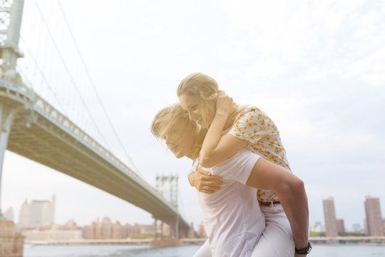 Playful Couple Under Brooklyn Bridge . New York City