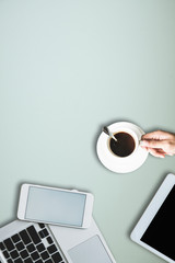 office equipment,laptop computer, smartphone with white screen over a notebook and cup of coffee. Top view with copy space, flat lay.