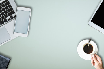 office equipment,laptop computer, smartphone with white screen over a notebook and cup of coffee. Top view with copy space, flat lay.