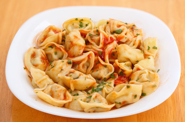 homemade boiled dumplings on a plate with tomato sauce
