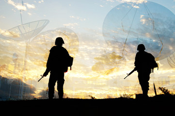 Soldier patrol silhouette and sattelite dish blur background