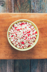 finely chopped crab sticks in a plate on a cutting board on an old wooden table. close up, top view, toned photo
