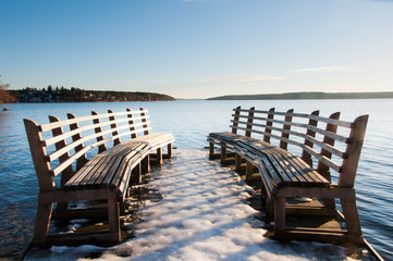 Benches on a pier reaching out onto a lake near Stockholm, Sweden.