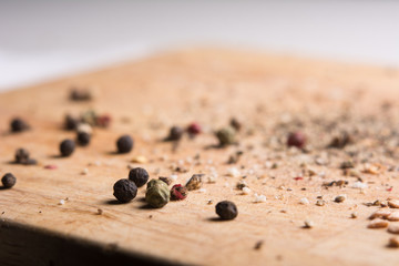 On a wooden board, ground pepper and peas