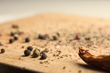 On a wooden board, ground pepper and peas