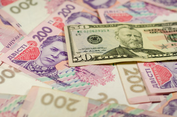 Fototapeta na wymiar Fifty dollars banknote on the background of ukrainian hryvnas