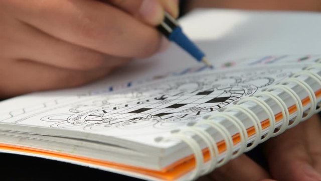 Close-up shot of a woman relaxing outdoor with drawing abstract pattern in sketch book