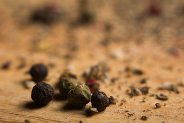 Close-up on a wooden board, ground pepper and peas
