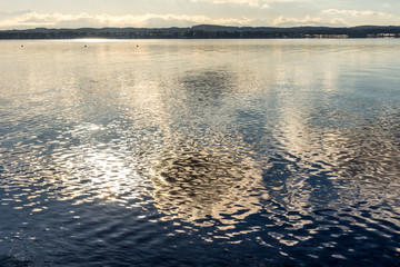 Wolken spiegeln sich im Wasser des Starnberger Sees