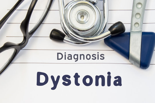 Neurological diagnosis of Dystonia. Neurological hammer, stethoscope and doctor's glasses lie on doctor workplace on sheet of notebook, labeled with the title of medical diagnosis of Dystonia