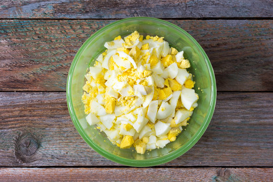 Finely Chopped Boiled Eggs In Green Plate On The Old Wooden Table. Close Up, Top View