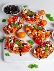 Tasty Traditional Tomato bruschetta with feta cheese topping, fresh basil and balsamic vinegar