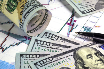 Graph with japanese candlesticks of euro dollar prices. Angled hundred us dollar bills above the...