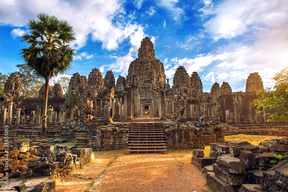 Wall mural ancient stone faces at sunset of bayon temple, angkor wat, siam