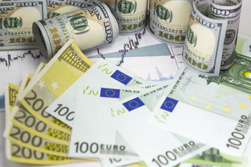 Euro dollar prices diagram with japanese candlesticks. Euro bills, rolled hundred us dollars staying on the chart. Part of euro bills with  flag 100 and 200 euro banknotes . Macro image.
