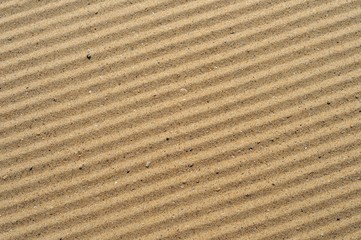 stripes on the sea sand after cleaning the beach from debris.
