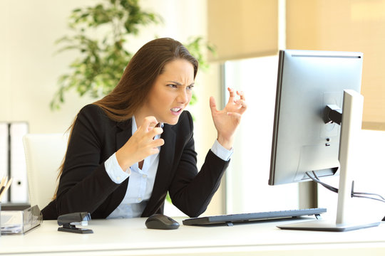 Furious businesswoman using a computer