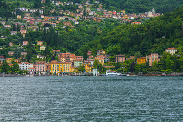 Fototapeta na wymiar View on coast line of Lake Como, Italy, Lombardy region. Italian landscape, with Mountain and city with many colorful buildings on the shore
