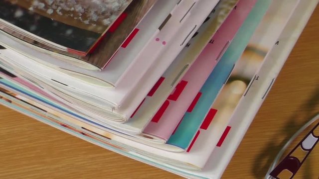 Magazines on table with eyeglasses
