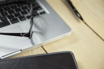 eyeglasses and notebook on wood background, black and white with