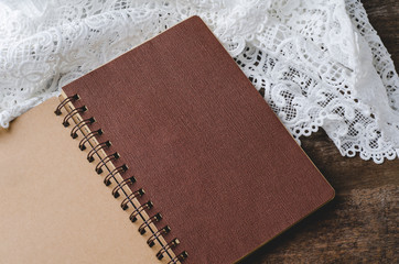 Blank notebook with lace on wooden background