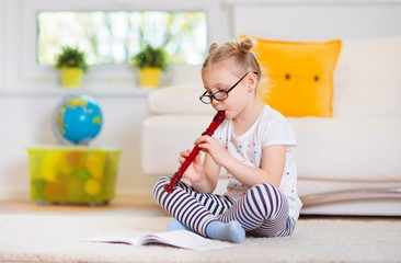 Portrait of pretty little girl with flute on floor © spass