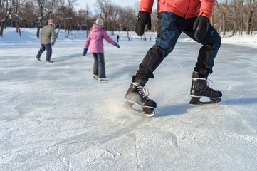 Close-up of ice skater braking on ice rink