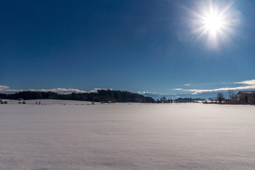 Die Sonne strahlt über die Winterlandschaft im Voralpenland