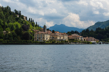 Fototapeta na wymiar View on coast line of Lake Como, Italy, Lombardy region. Italian landscape, with Mountain and city with many colorful buildings on the shore