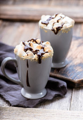 S'mores drink. Two mugs of hot chocolate with marshmallows on a wooden table. Cocoa.