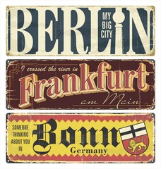 Vintage tin sign collection Germany cities. Berlin. Frankfurt. Bonn. Germany. Capital. Retro souvenirs or postcard templates on rust background.