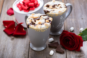 S'mores drink. Two mugs of hot chocolate with marshmallows on a wooden table. Cocoa. Rose petals. Valentine. Gift.