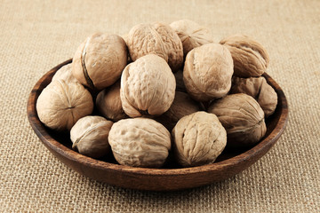 Walnuts on a wooden plate.  Image in natural colos.