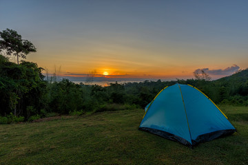 Tourist tent in camp among meadow in the mountain at sunrise