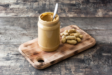Peanut butter jar on wooden table. 
