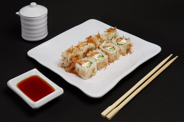 Portion of bonito rolls served on plate with soy sauce and woode