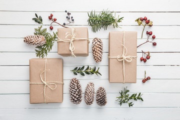 Fototapeta na wymiar Homemade wrapped rustic brown paper packages with various natural things on white wooden surface